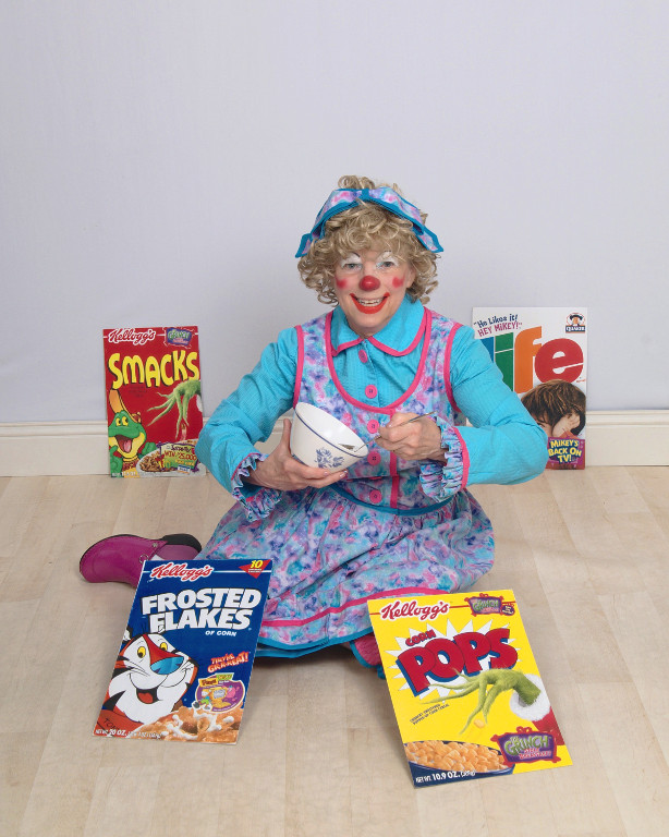 Rainbow the Clown surrounded by cereal boxes