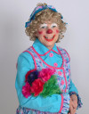 Rainbow the Clown poses, holding flowers